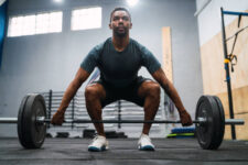 the full length of a man exercising in a gym