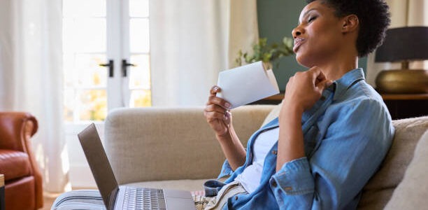 a beautiful woman is sitting on her home sofa having hot flashes from menopause