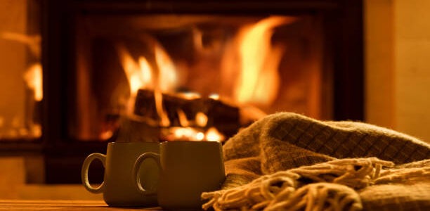 two tea mugs by a throw near an open flame