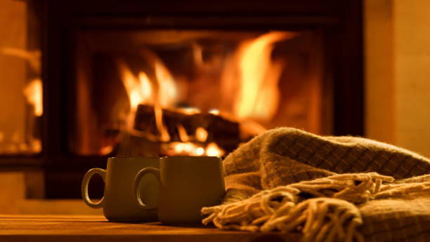 two tea mugs by a throw near an open flame