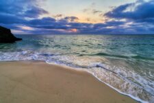 a beautiful beach with water washing up ashore