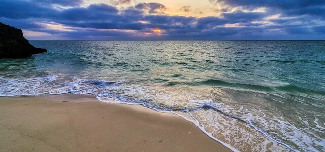 a beautiful beach with water washing up ashore